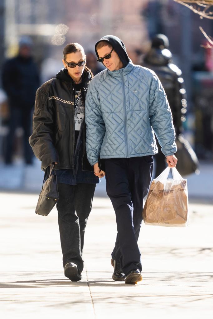 Marc Kalman and Bella Hadid holding hands on a walk