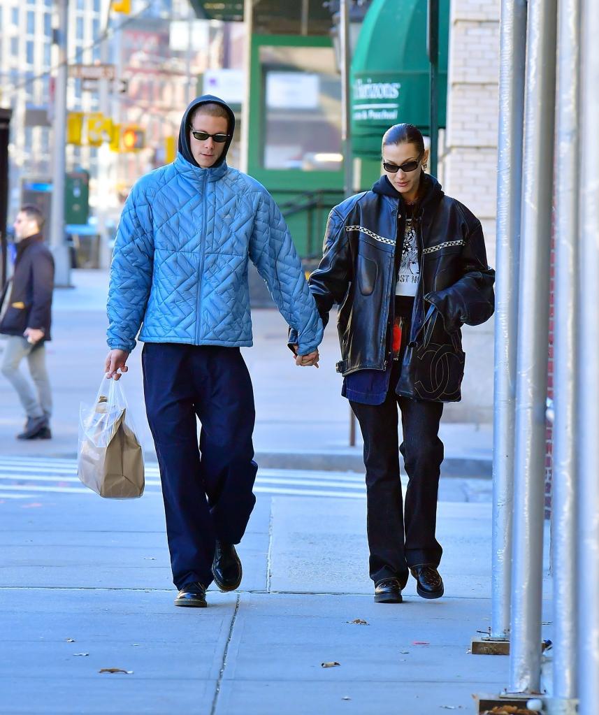 Marc Kalman and Bella Hadid holding hands on a walk