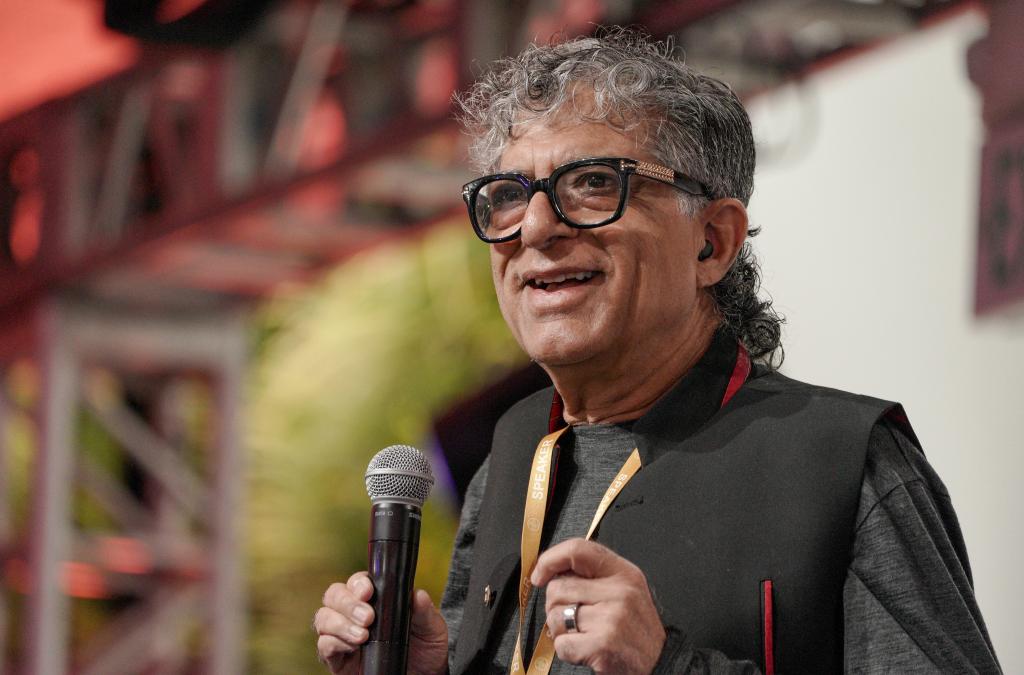 Deepak Chopra speaking on a stage.