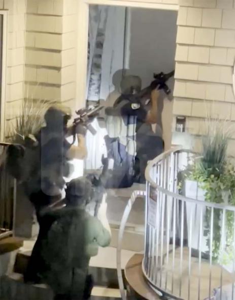 A screenshot of security footage police officers and a SWAT team outside Elizabeth Lyn Vargas' home.