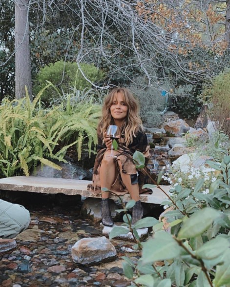 Halle Berry holds wine in the forest