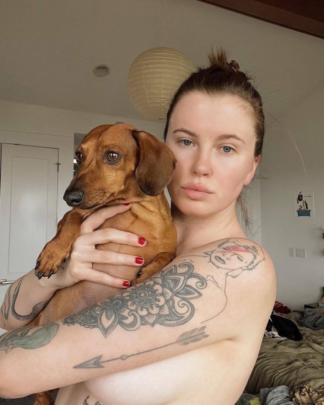 Ireland Baldwin uses an adorable dog to cover up her topless self.