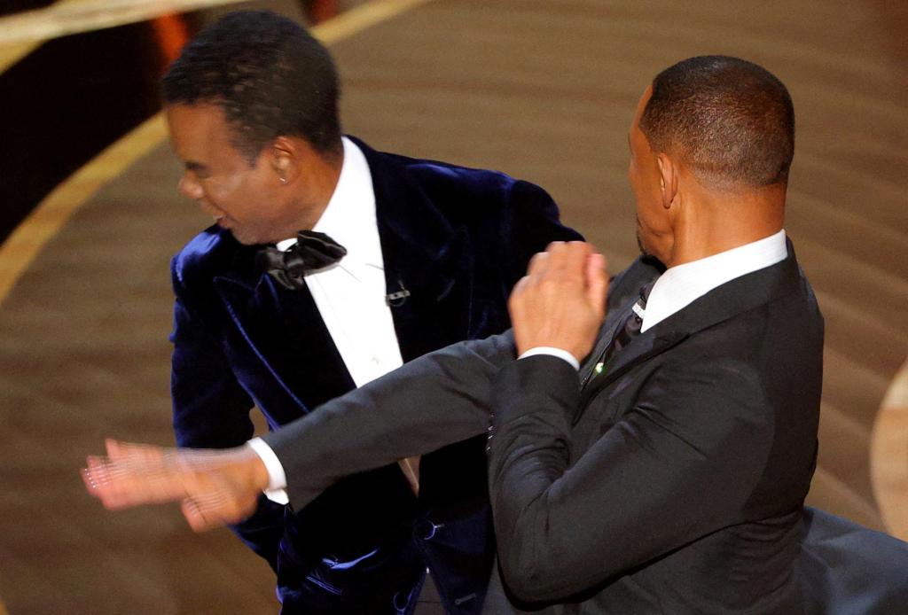 Will Smith (R) hits Chris Rock as Rock spoke on stage during the 94th Academy Awards in Hollywood, Los Angeles, California, U.S., March 27, 2022.