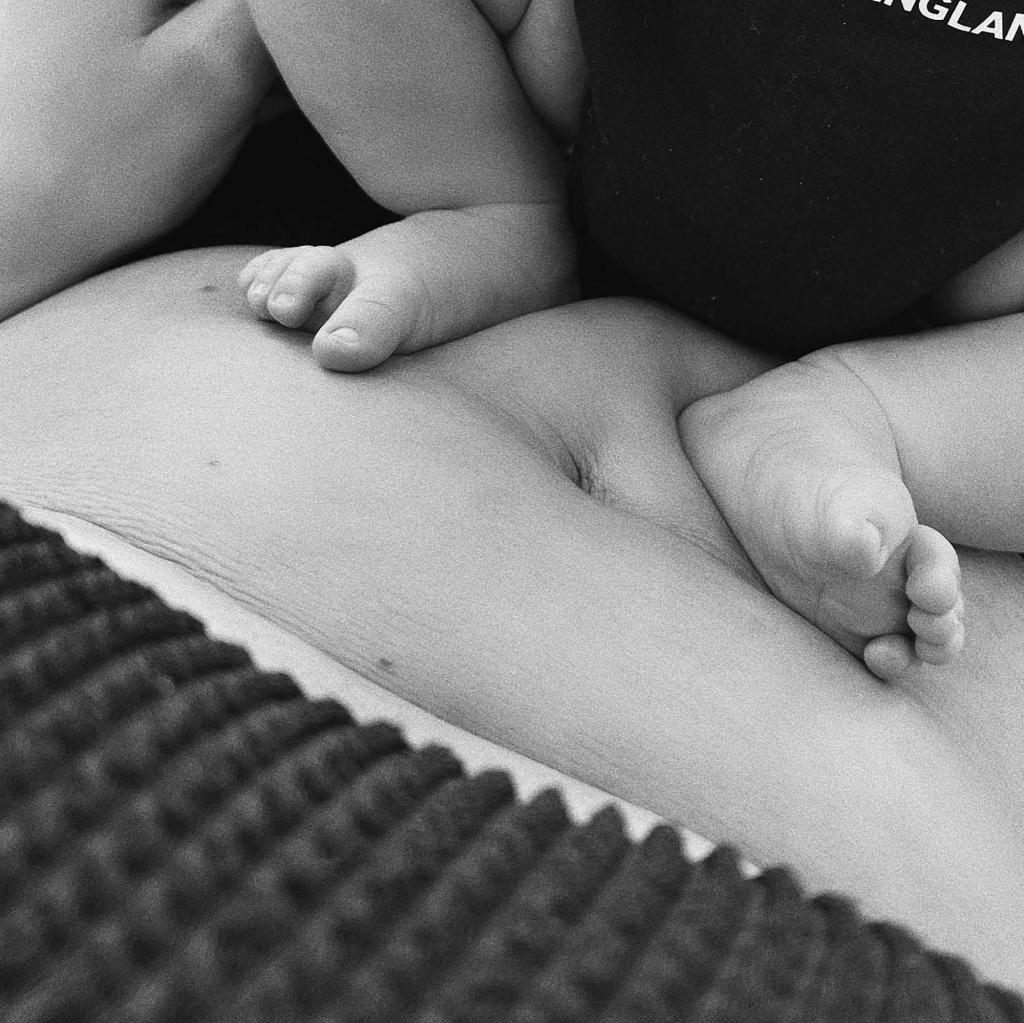 A close-up of Kylie Jenner's son's feet on her stomach.