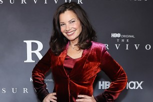 Fran Drescher standing on a red carpet with her hands on her hips.