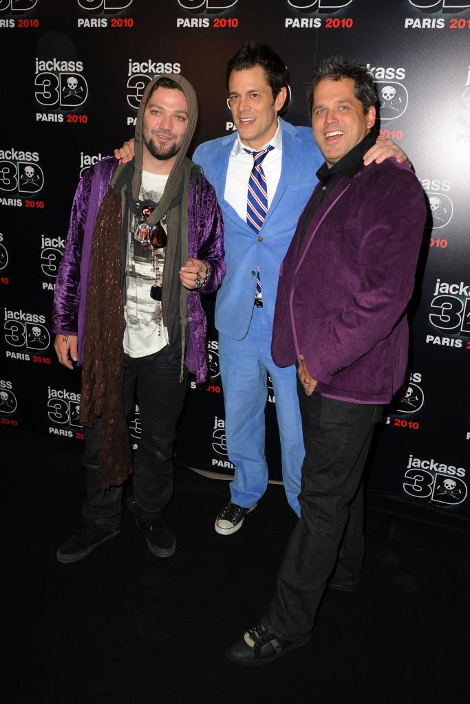 Bam Margera, Johnny Knoxville and Jeff Tremaine posing on a red carpet together.