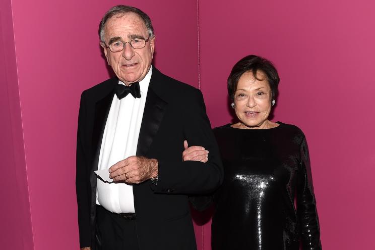 Harry and Linda Macklowe posing arm in arm in front of a pink wall.