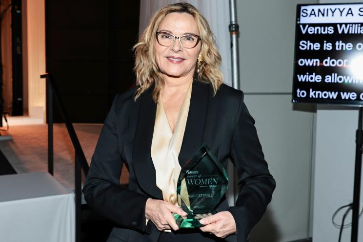 Kim Cattrall holding her award for her work with the Actros Fund.