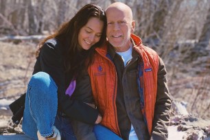 Bruce Willis and Emma Heming sitting outdoors.