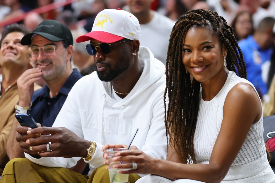 Turning up the heat: Dwyane Wade cheers on his former Miami teammates with wife Gabrielle Union as they take on the Philadelphia 76ers in Game 2 of the Eastern Conference Semifinals.