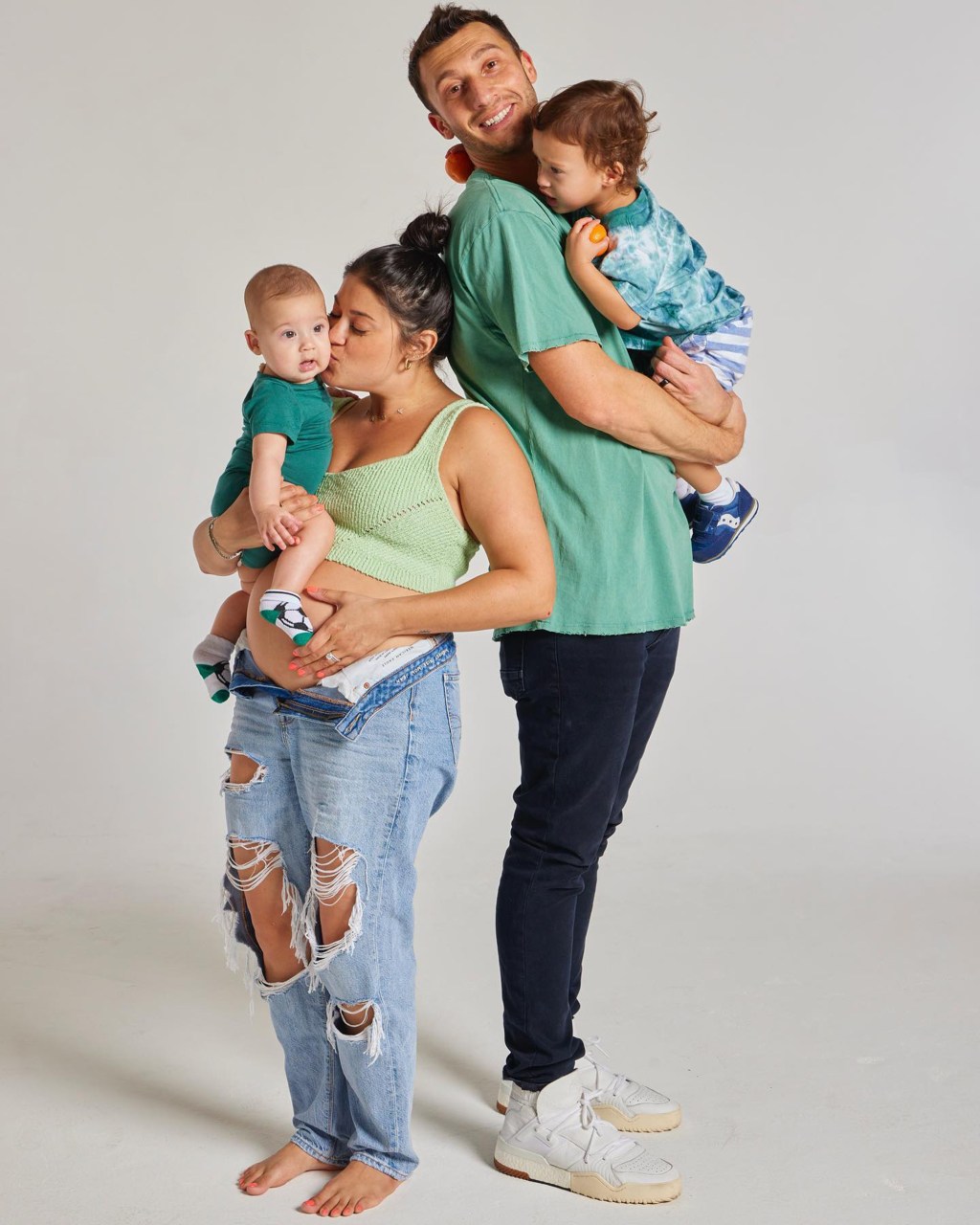 Pregnant Loren Brovarnik and Alexei Brovarnik posing for a photo with their kids.