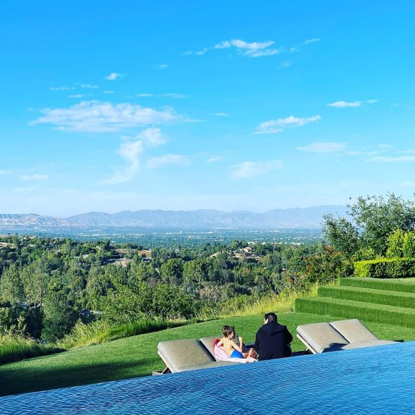 Scott Disick and son Reign Disick sitting outside.