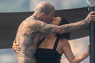 Travis Barker and Kourtney Kardashian kiss on a boat