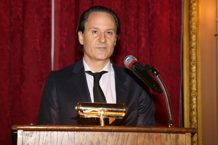 David Hryck speaks from a podium at an event.