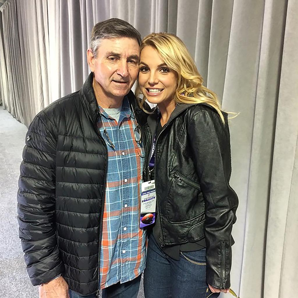 Britney Spears and Jamie Spears smiling backstage at a concert.