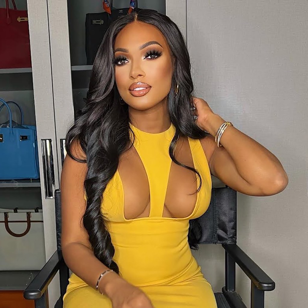 Lesa Milan posing in a yellow dress with cutouts.