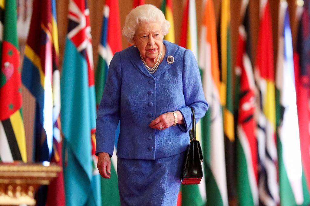 Queen Elizabeth II walking in front of Commonwealth flags.