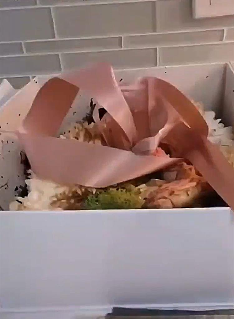 A screenshot of Ramona Singer's Instagram Story showing a white box with flowers and a pink ribbon.