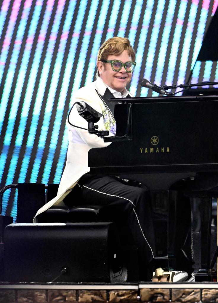 Elton John performing at a piano.