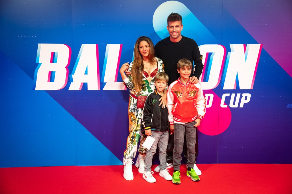 Shakira, Gerard Piqué and their two children on a red carpet.