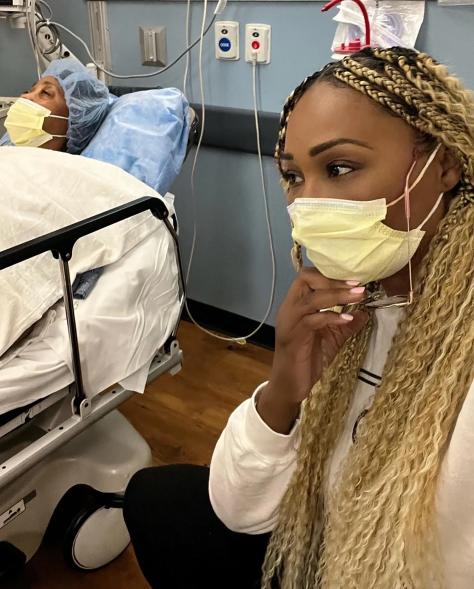 A selfie of Cynthia Bailey wearing a face mask while her mom, Barbara Ford Morris, lies in a hospital bed next to her.