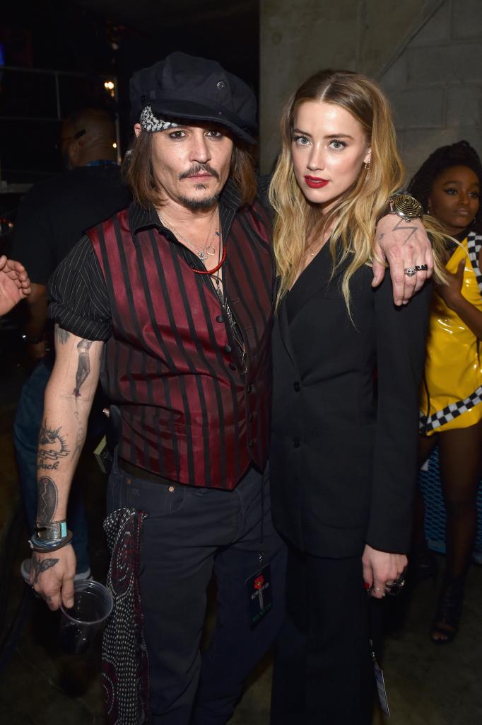 Johnny Depp wrapping his arm around Amber Heard at an event.