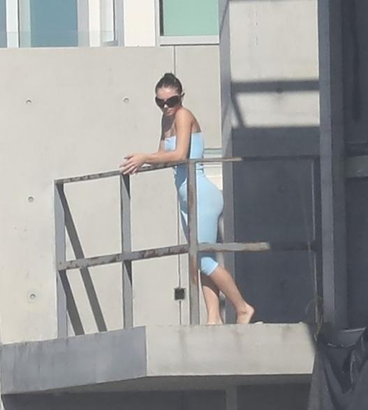 Kanye West's mystery gal pal hangs out on his balcony.