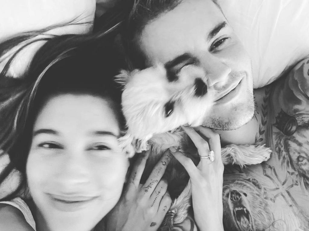 A selfie of Hailey Bieber and Justin Bieber snuggling with their dog