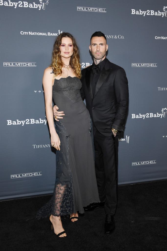 Behati Prinsloo and Adam Levine on a red carpet.