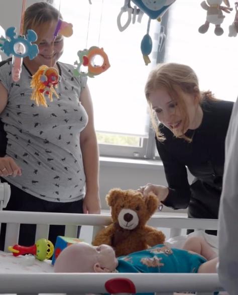 Jessica Chastain talking to a patient while looking at toys in a crib in the children's hospital in Kyiv