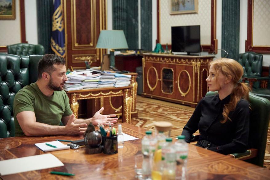 Jessica Chastain talking to Ukraine President Volodymyr Zelensky in a conference room