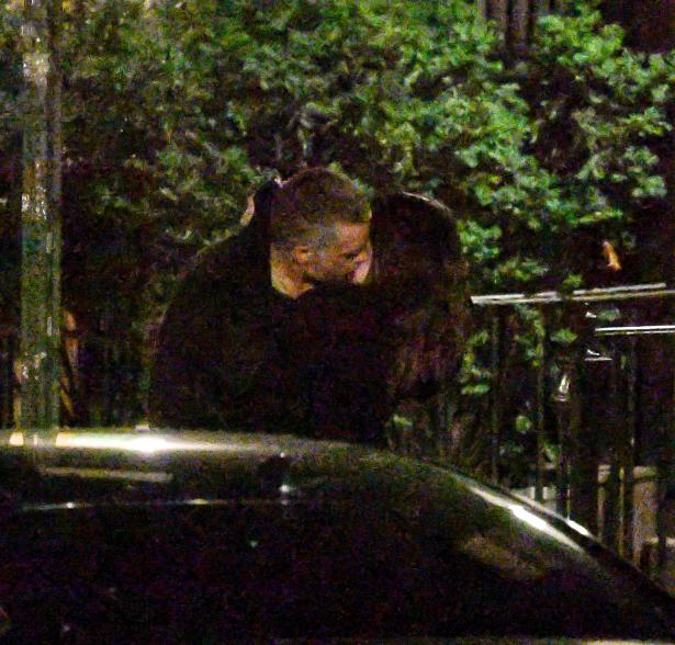 Emily Ratajkowski and Orazio Rispo kissing on a sidewalk