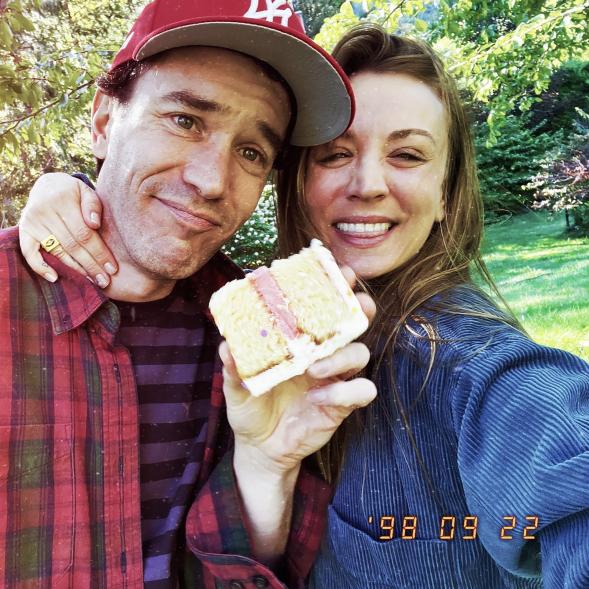 Kaley Cuoco and Tom Pelphrey smiling with cake.