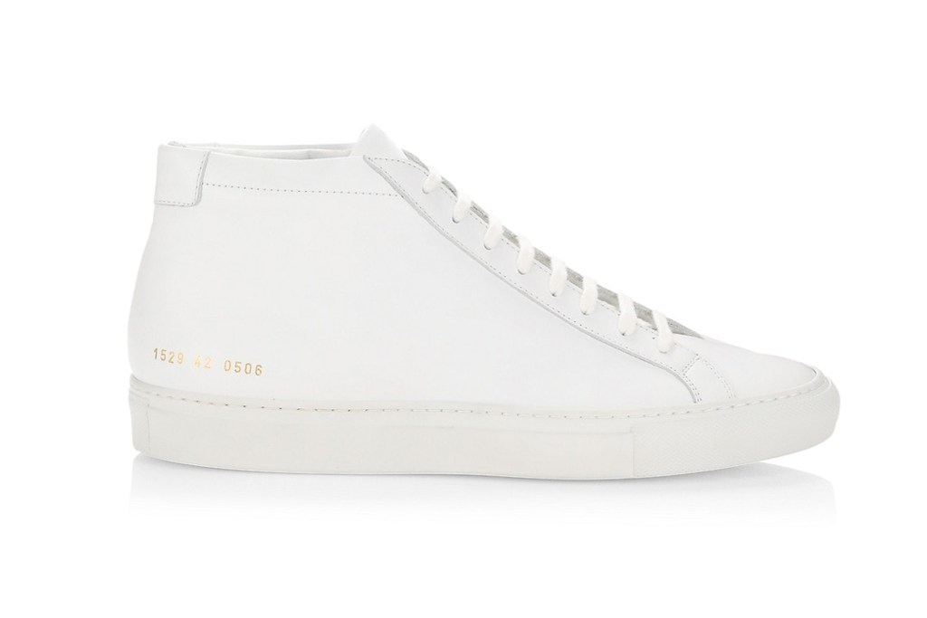 A white Common Projects mid-top sneaker