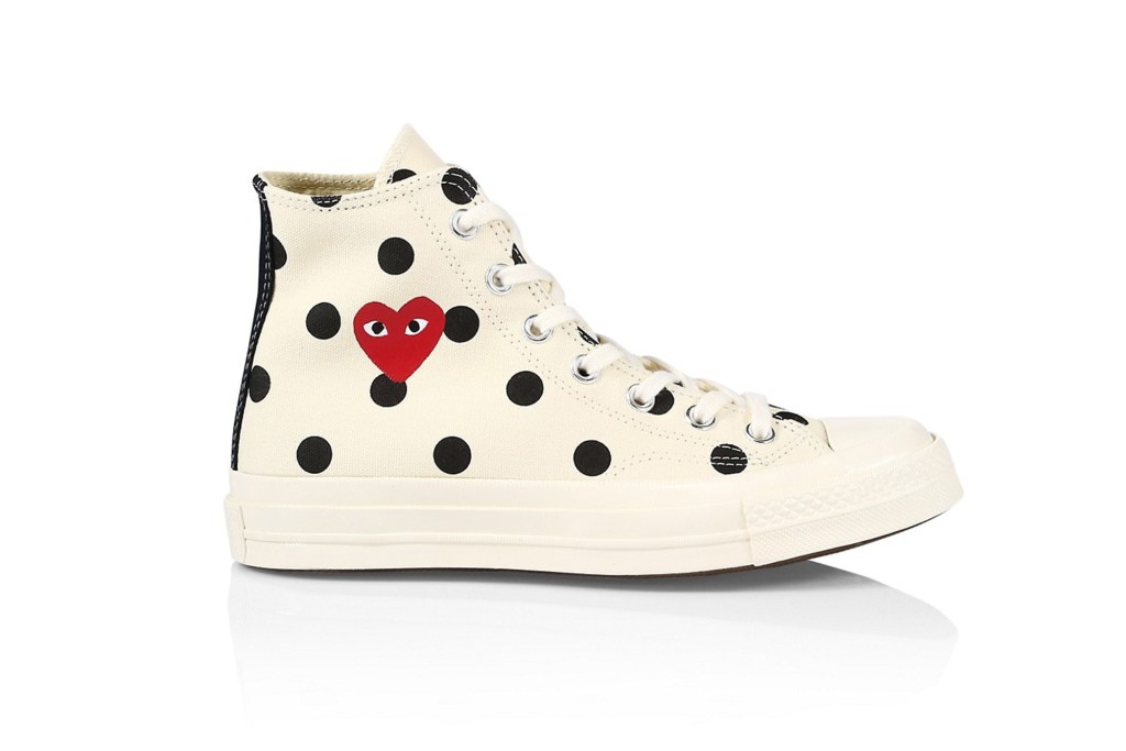 A white polka-dotted Converse high top sneaker with a red heart on it