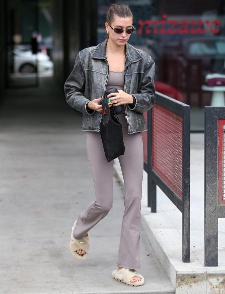 Hailey Bieber walking outside in slippers and a matching set