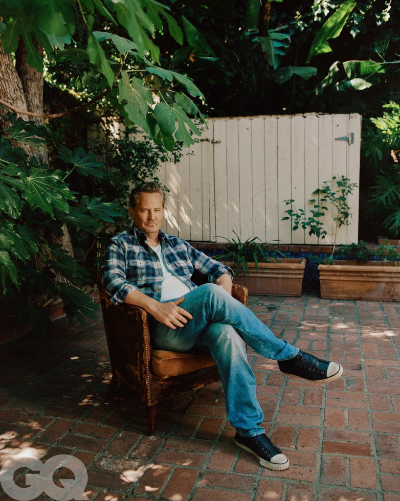 Matthew Perry sitting in a chair on a patio.