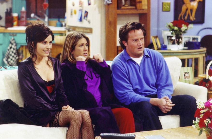 Courteney Cox, Jennifer Aniston and Matthew Perry sitting on a couch on "Friends."