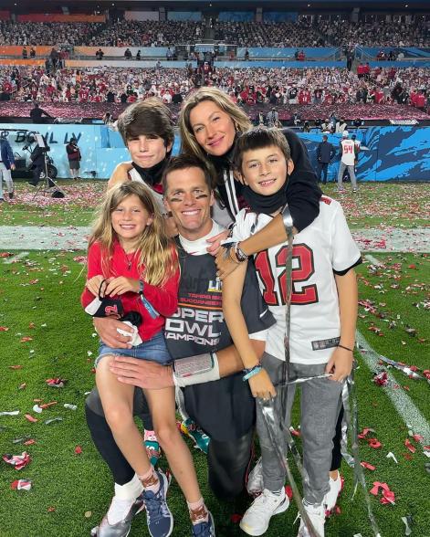 Tom Brady and Gisele Bündchen with their kids on a football field.