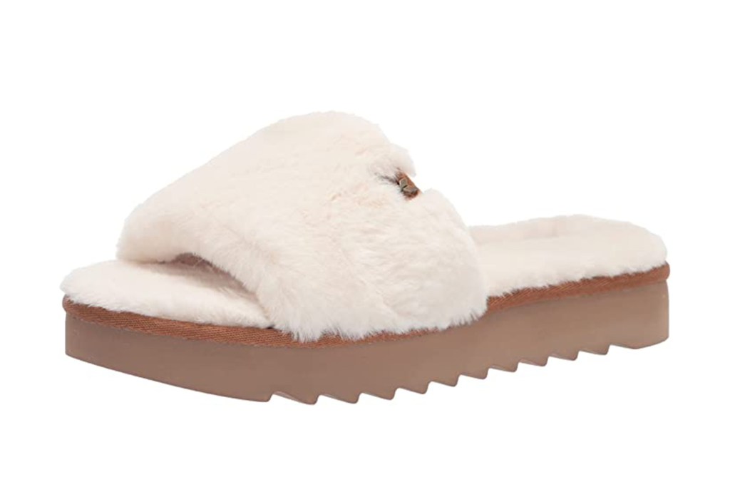 A white Ugg slide with a tan rubber sole