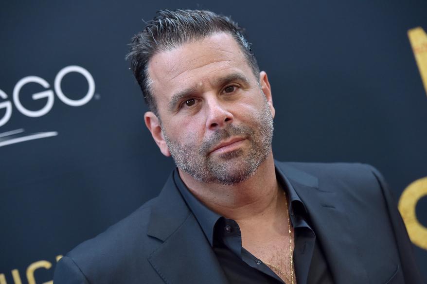 Randall Emmett standing on a red carpet.