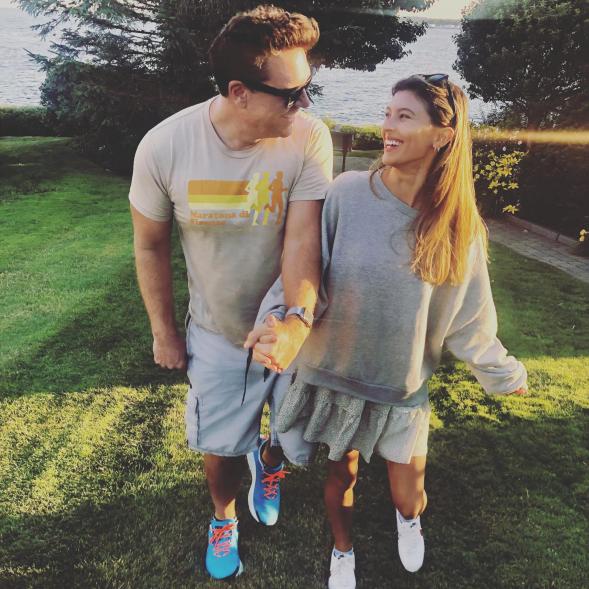 Dane Cook and Kelsi Taylor holding hands outdoors.