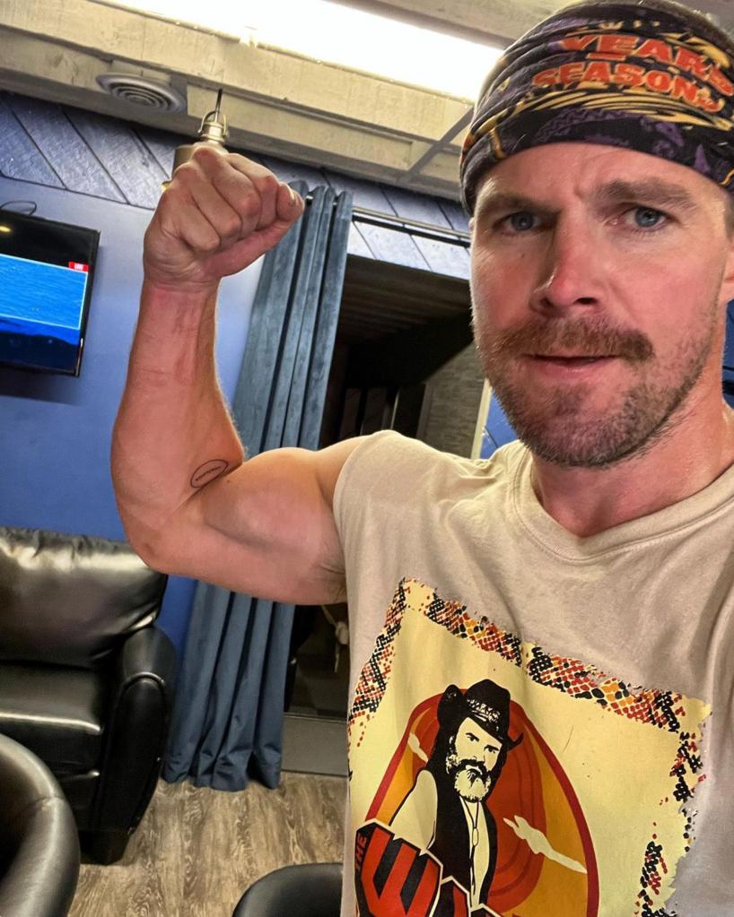 Stephen Amell flexing his bicep in a selfie.