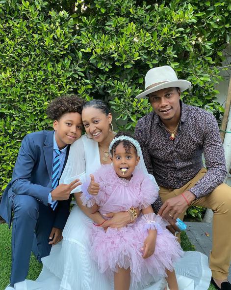 Tia Mowry and Cory Hardict with their two kids outside.