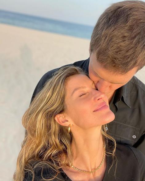 Tom Brady and Gisele Bündchen kiss on the beach.