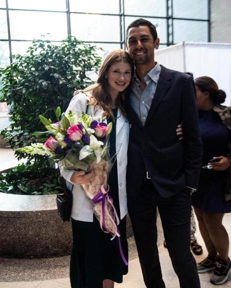 Jennifer Gates holds flowers while embracing Nayel Nassar