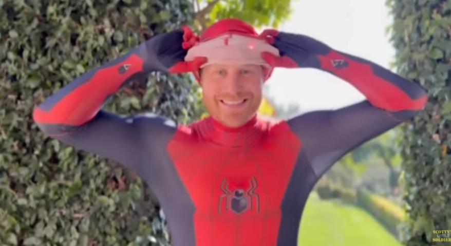 Prince Harry revealing his Spider-Man mask to show his face.