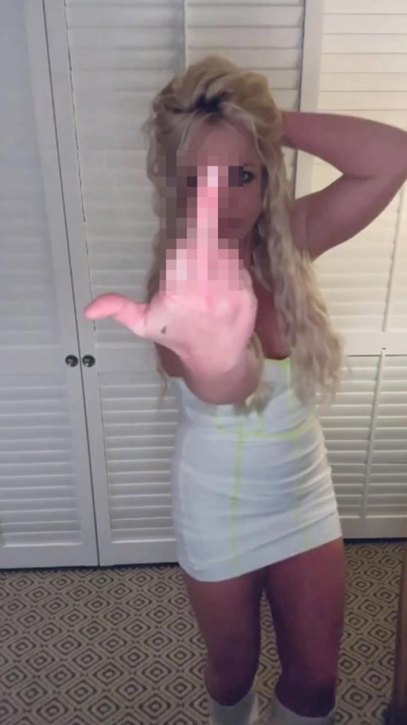 Britney Spears holding up her middle finger.