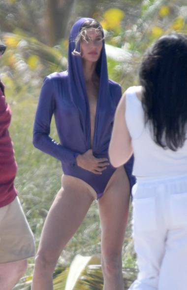 Gisele Bündchen modeling a purple swimsuit.