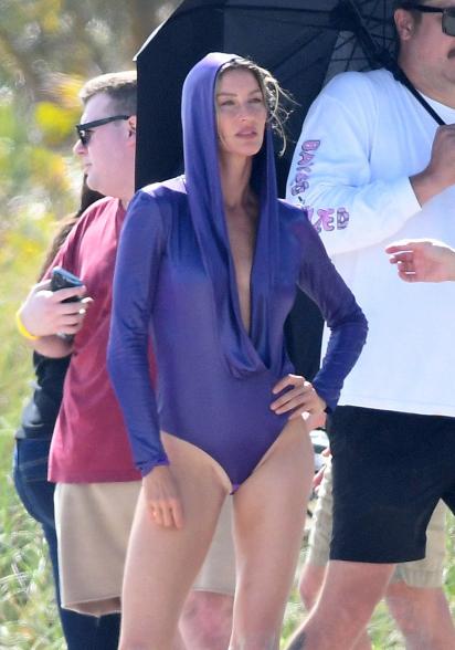 Gisele Bündchen modeling a purple swimsuit.